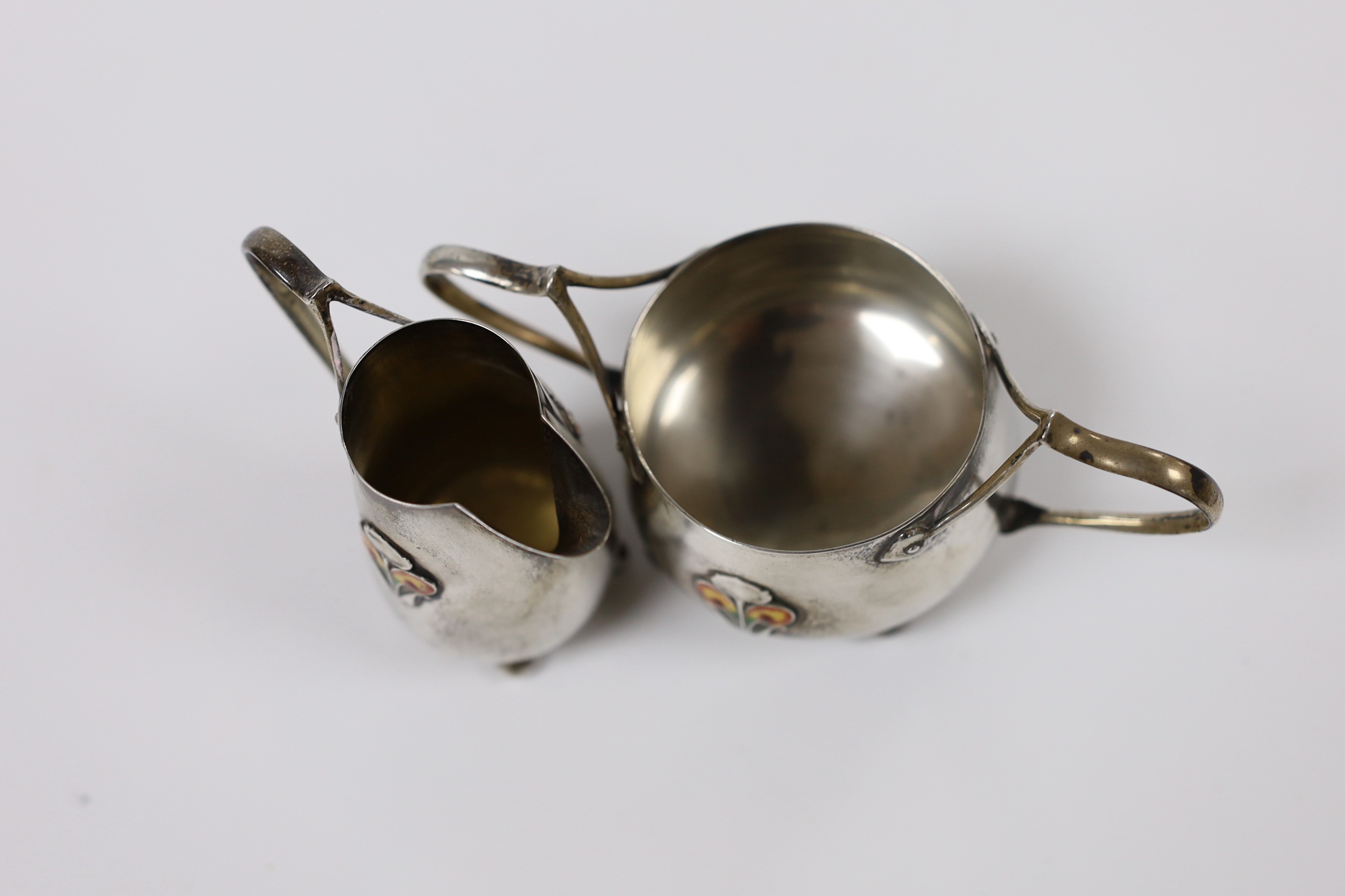An Edwardian Art Nouveau silver and enamelled cream jug and sugar bowl, C & Co, Birmingham, 1905, jug height 76mm, gross weight 123 grams.